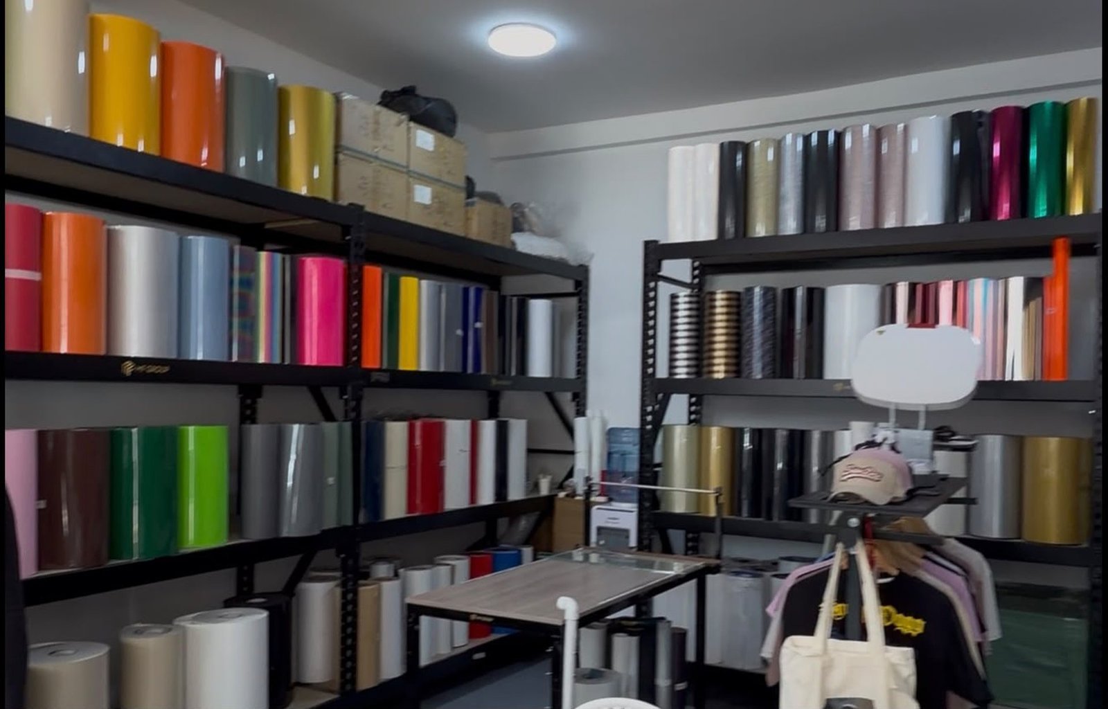 Estantes de la bodega de MF Group repletos de rollos de vinilo textil de todos los colores